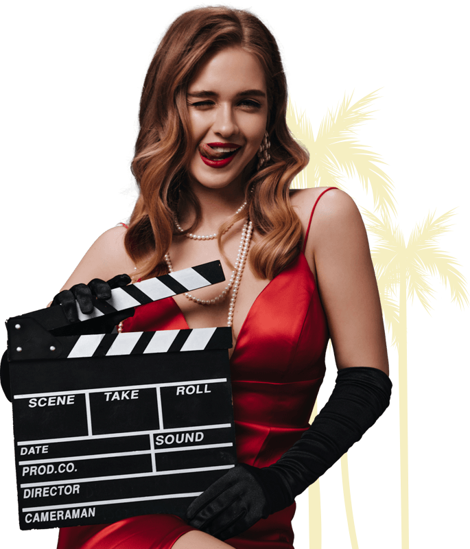 Mulher segurando uma claquete com palmeiras de fundo